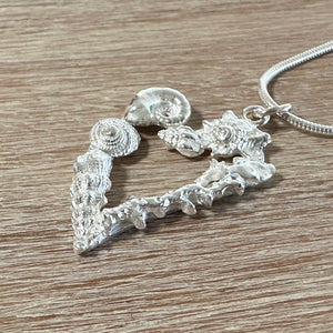 Heart shaped fine silver pendant with little handcart shells in silver