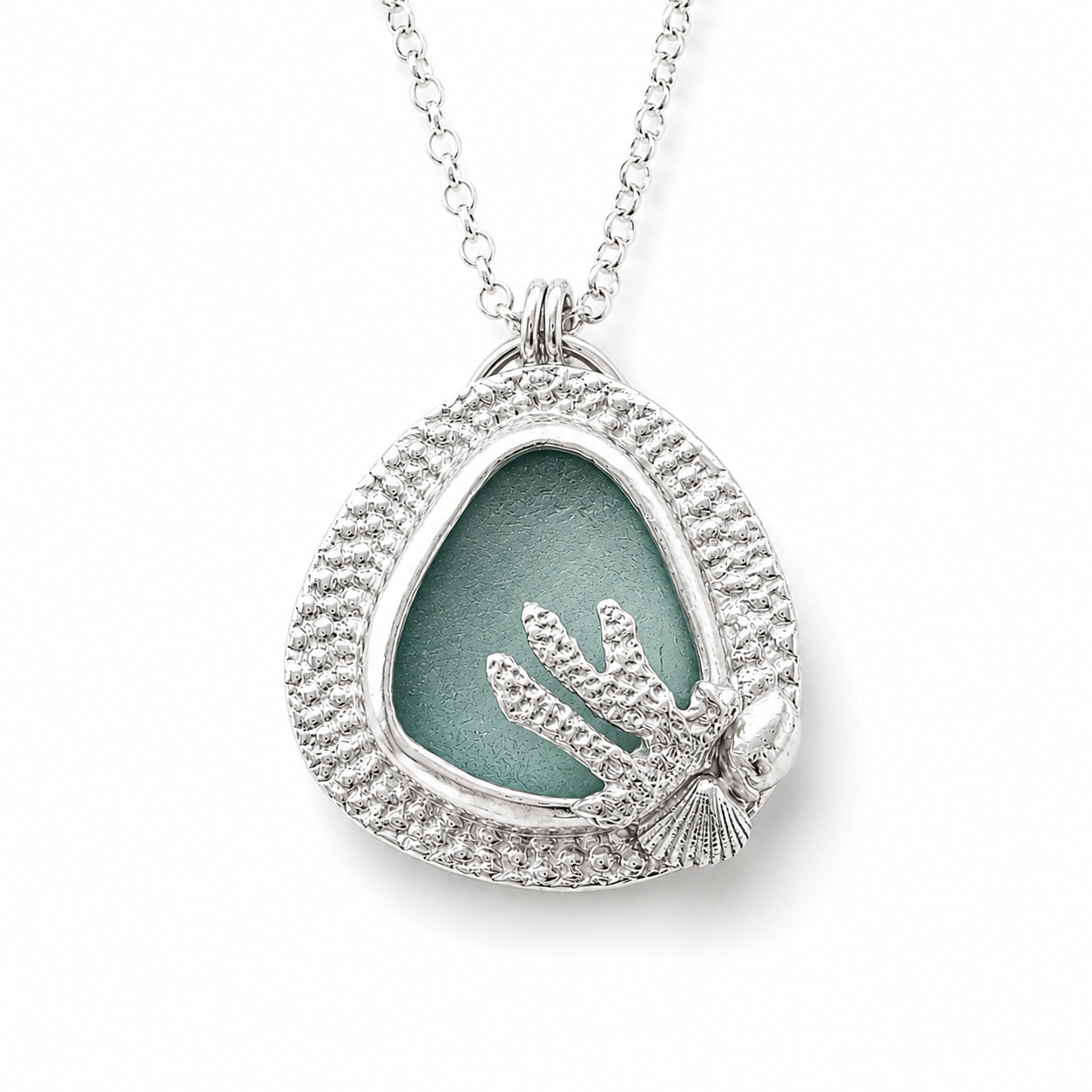 Fine silver  handcrafted pendant with genuine bezel set Sea Glass in a soft teal and tiny shells and small coral accent on white background