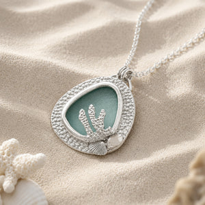 Fine silver bezel set Sea glass pendant on sandy beach