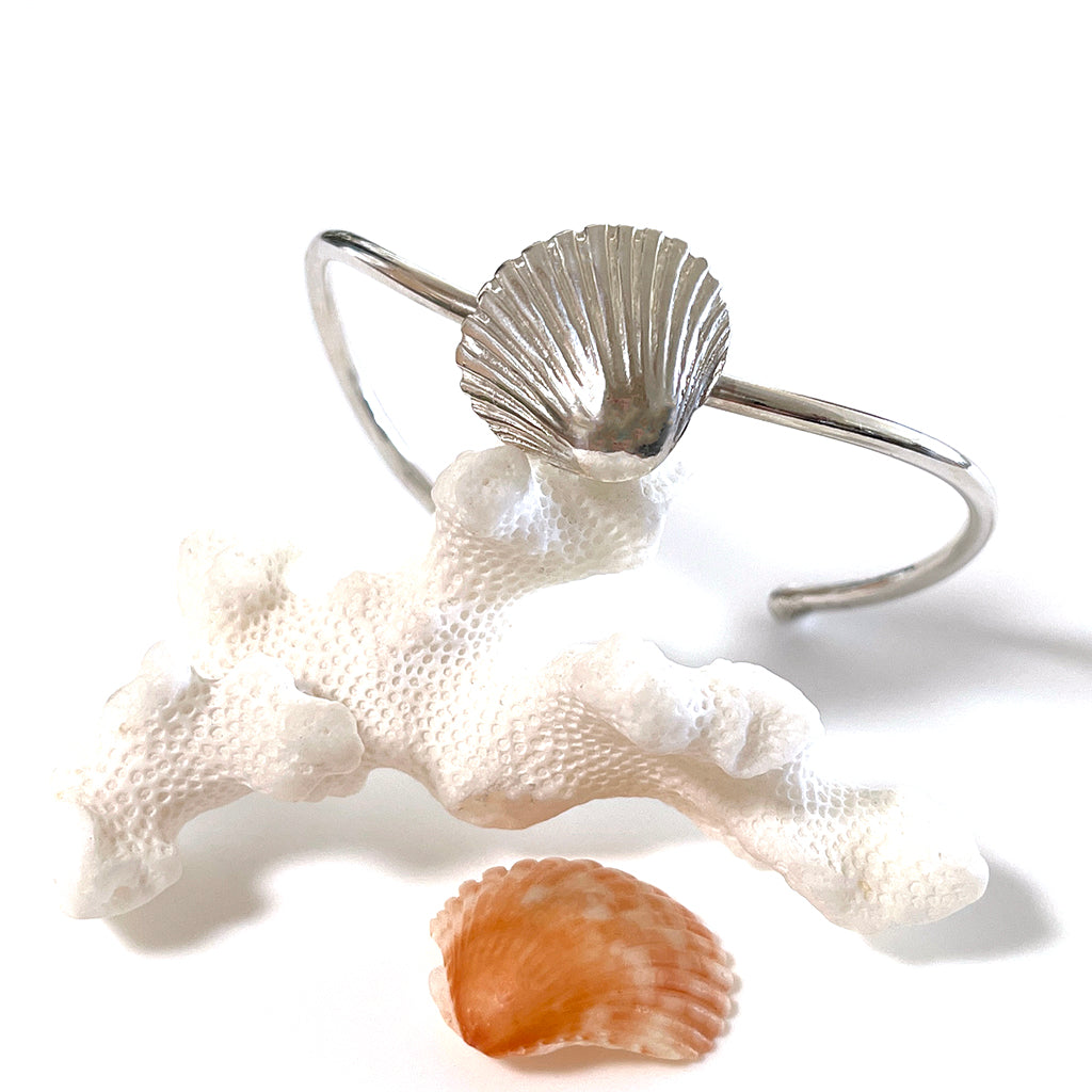 Sun Rays Sea Shell Cuff Bracelet , displayed on natural coral