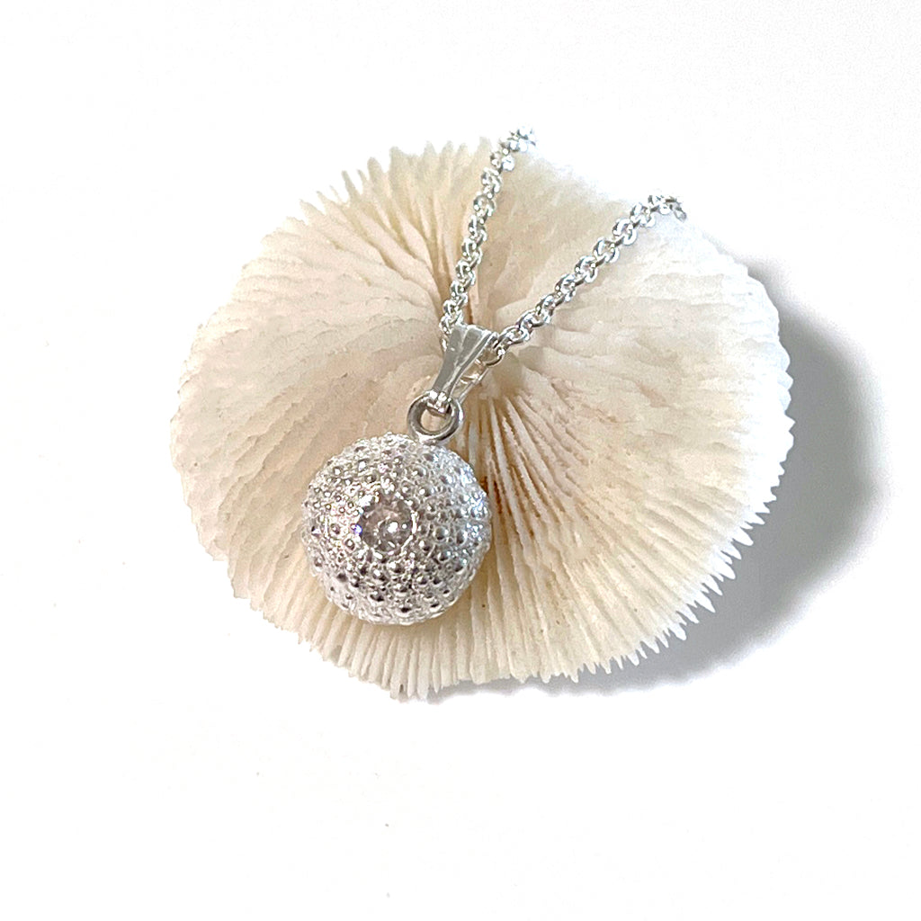 Close-up of handcrafted pure silver Baby Sea Urchin Necklace with Preciosa white diamond, reflecting coastal elegance.