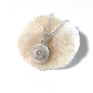Close-up of handcrafted pure silver Baby Sea Urchin Necklace with Preciosa white diamond, reflecting coastal elegance.