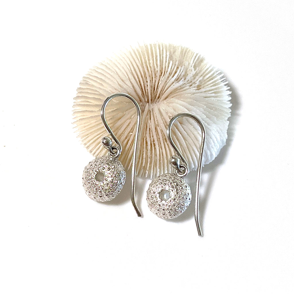 Handcrafted pure silver Sea Urchin Earrings featuring intricate natural texture molded from real urchin shells. Ocean-inspired jewelry by Coastalstyle Australia shown against neutral background with coral.