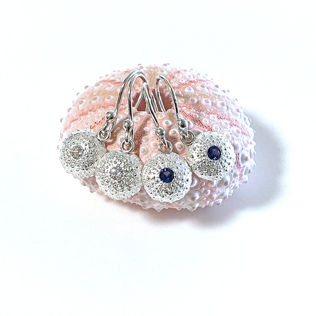 Handcrafted pure silver Baby Sea Urchin Earrings featuring intricate natural texture molded from real tiny urchin shells. Lightweight ocean-inspired jewelry by Coastalstyle Australia shown against a pink sea urchin shell.