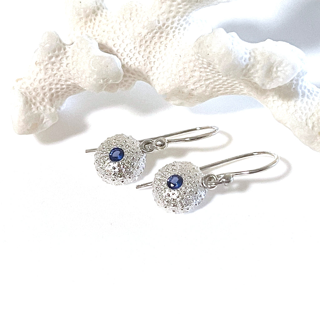 Handcrafted pure silver Baby Sea Urchin Earrings featuring intricate natural texture molded from real tiny urchin shells. Lightweight ocean-inspired jewelry by Coastalstyle Australia shown against a pink sea urchin shell.