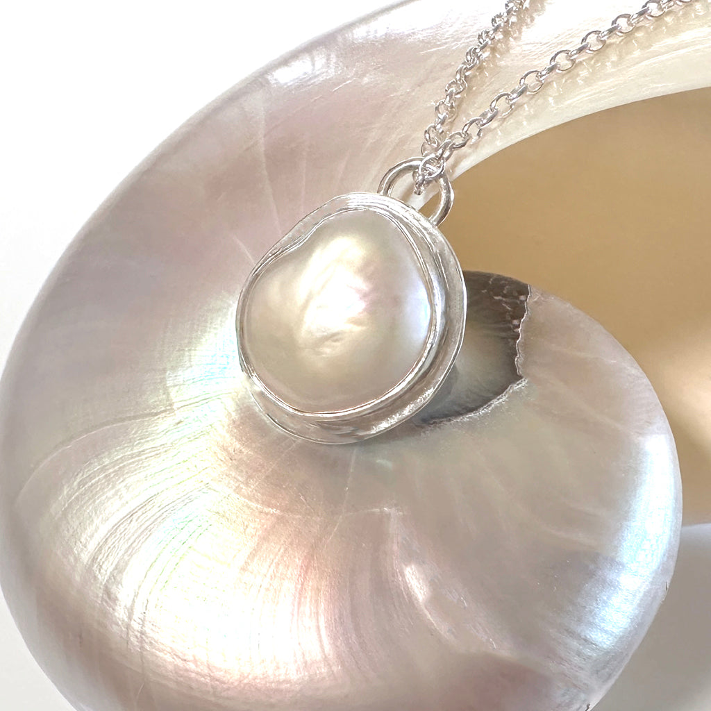 Handcrafted Silver Sands Pearl Necklace showcasing lustrous Australian pearl set in textured recycled silver with sand-inspired finish. Elegant ocean jewelry by Coastalstyle Australia displayed on a nautilus shell