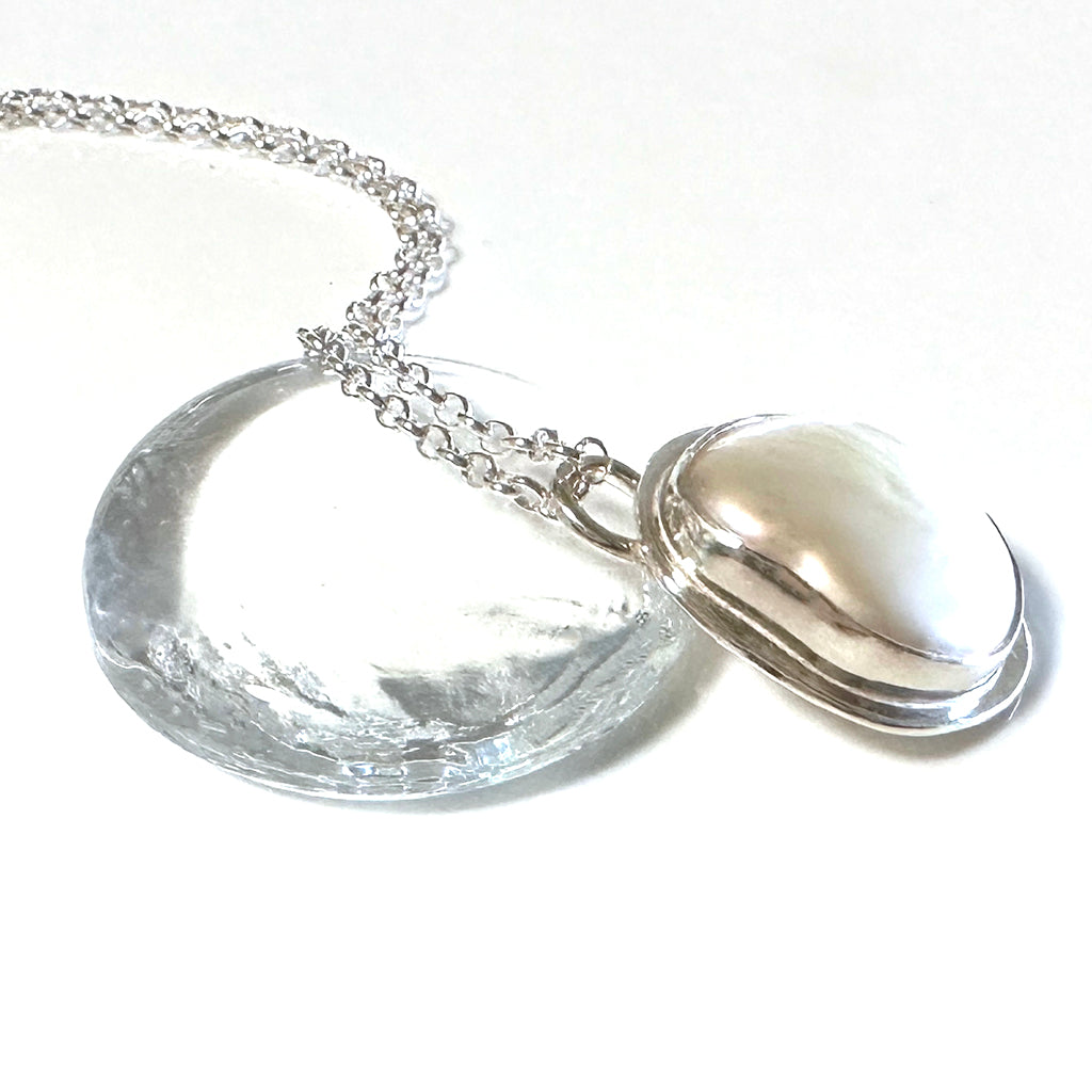 Handcrafted Silver Sands Pearl Necklace showcasing lustrous Australian pearl set in textured recycled silver with sand-inspired finish. Elegant ocean jewelry by Coastalstyle Australia displayed on glass pebble
