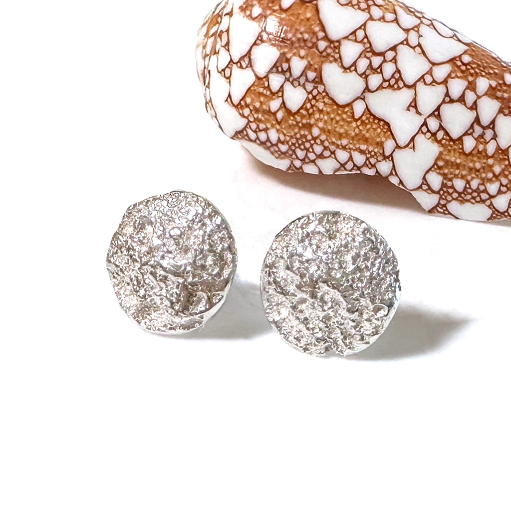 Handcrafted Beach Rock Earrings featuring smooth, rounded Pure silver forms from weathered coastal pebbles shown with shell. Minimalist ocean-inspired jewelry by Coastalstyle Australia.