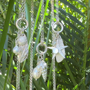variations of sea inspired silver charms and pearls on  silver chains