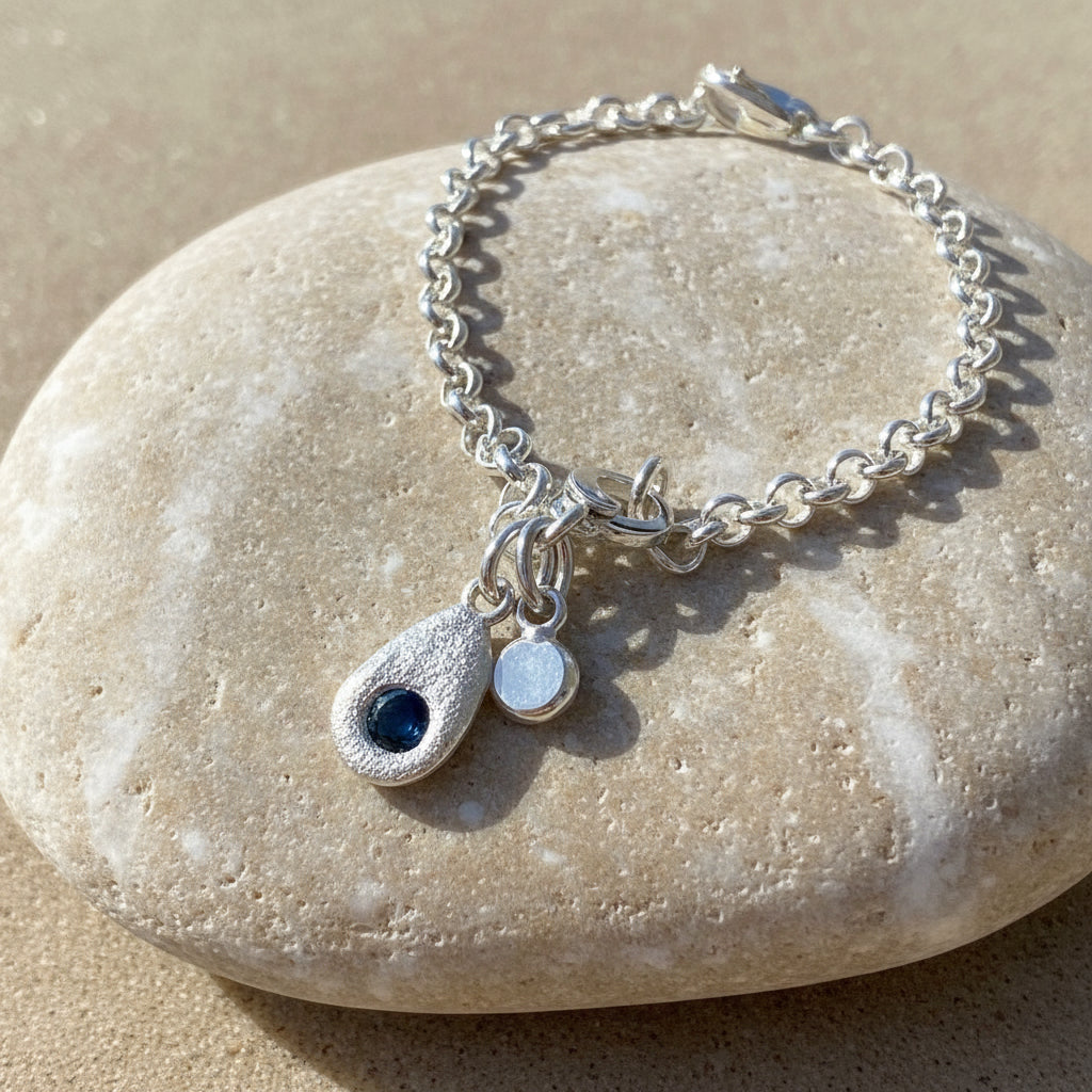 Sapphire Tide bracelet with hand-cast silver pebble and Australian sapphire on white background