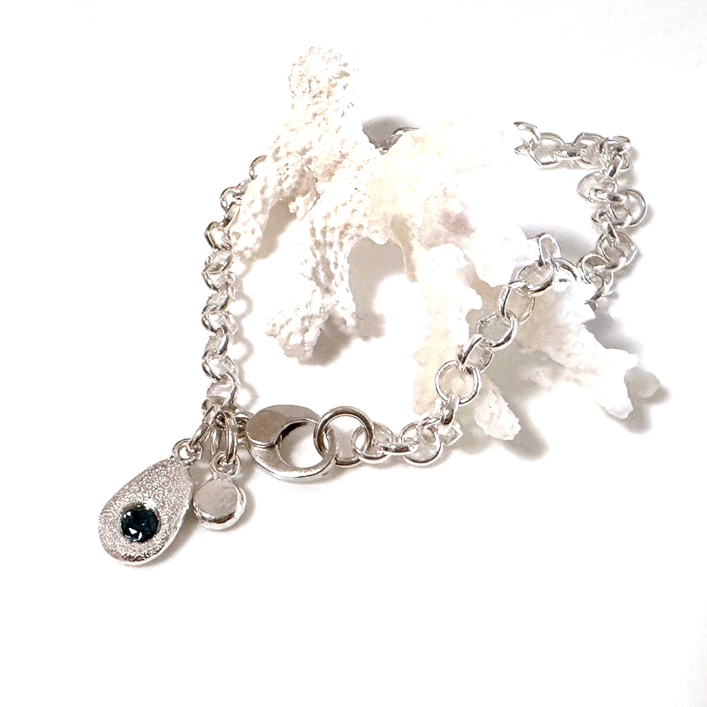 Sapphire Tide bracelet with hand-cast silver pebble and Australian sapphire on white background