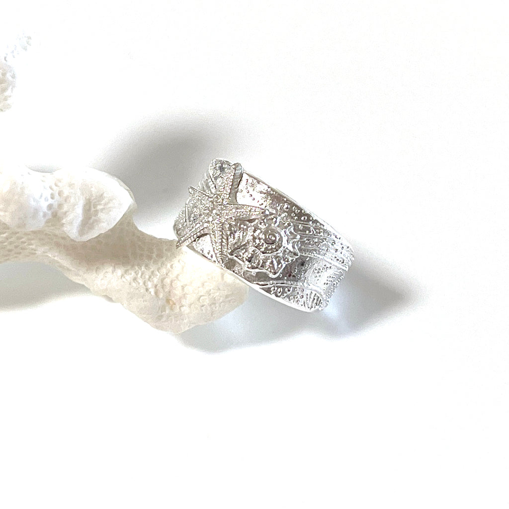 Tidal Sea Star adjustable pure silver ring with textured sea star design displayed on coral