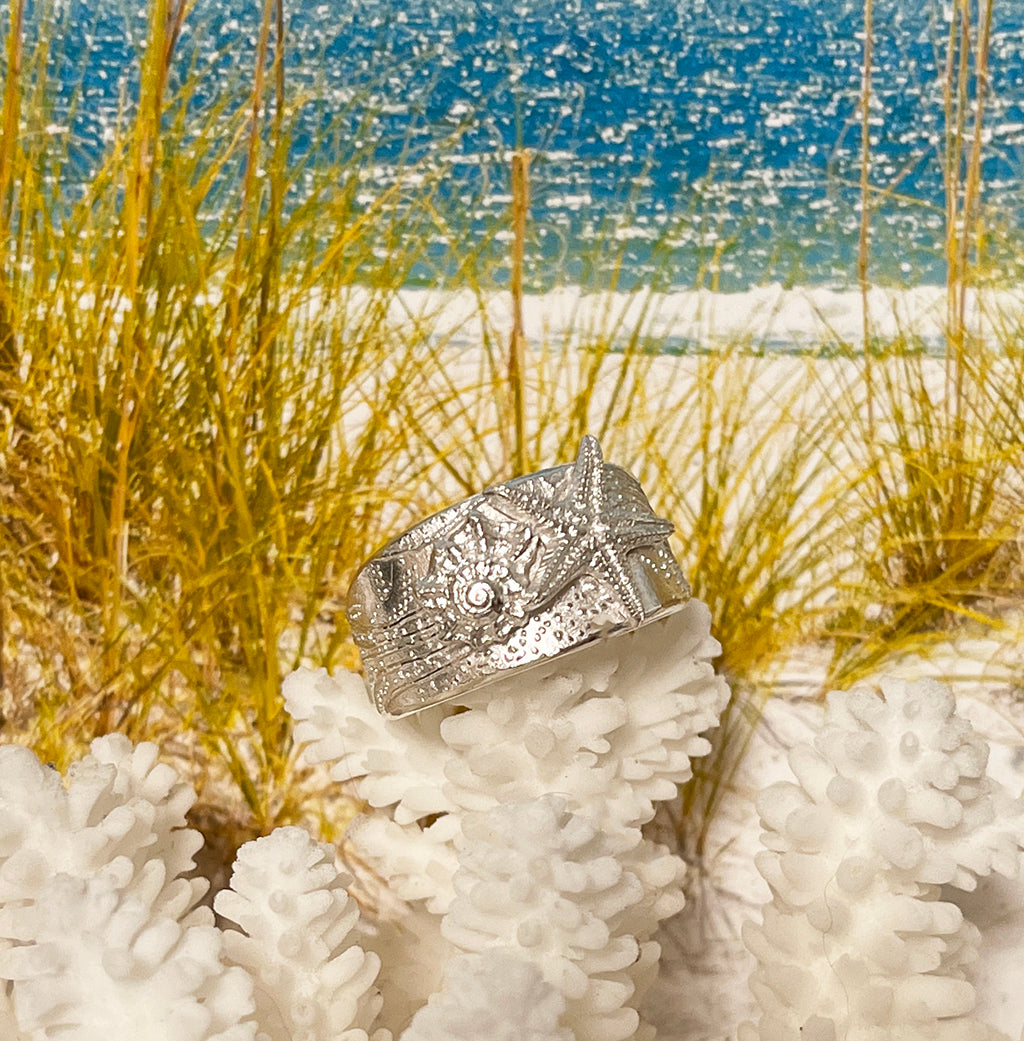 Tidal Sea Star adjustable pure silver ring with textured sea star design displayed on coral