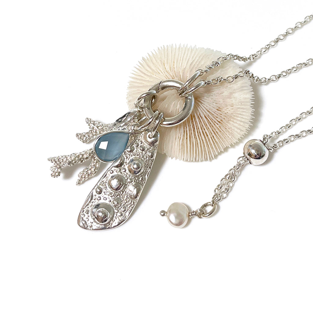 Close-up of the Hardy Reef Necklace by Coastalstyle Australia, showcasing a handcrafted pure silver coral pendant with a faceted chalcedony stone.​