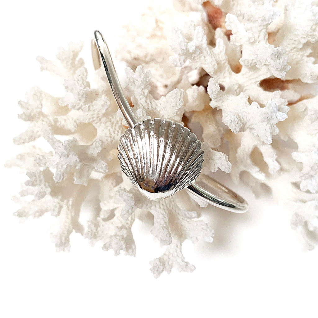 Sun Rays Sea Shell Cuff Bracelet , displayed on natural coral